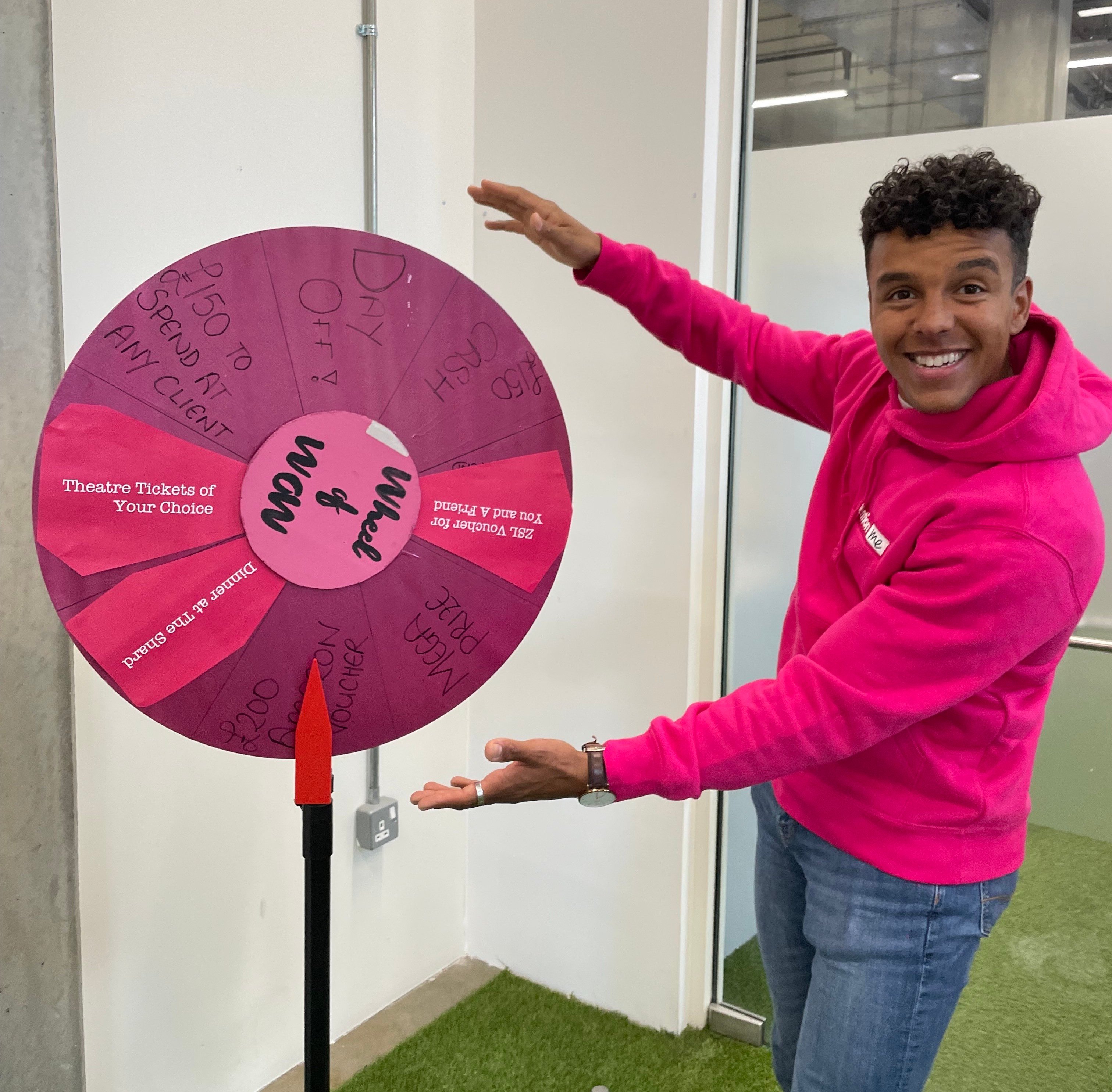 Dom poses with Mention Me's "Wheel of Wow"