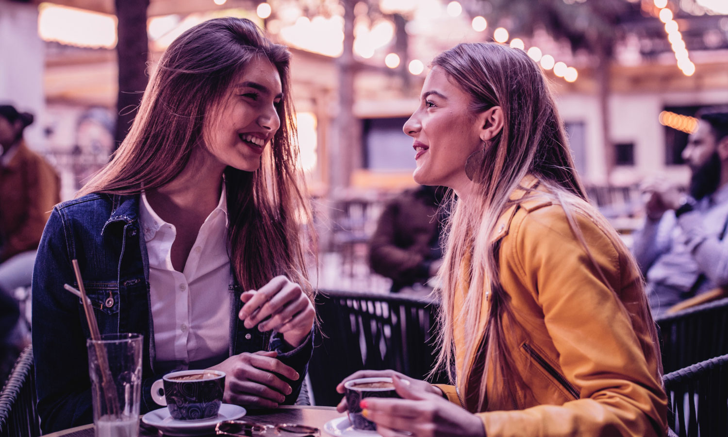 Photograph of two women having a friendly conversation over coffee
