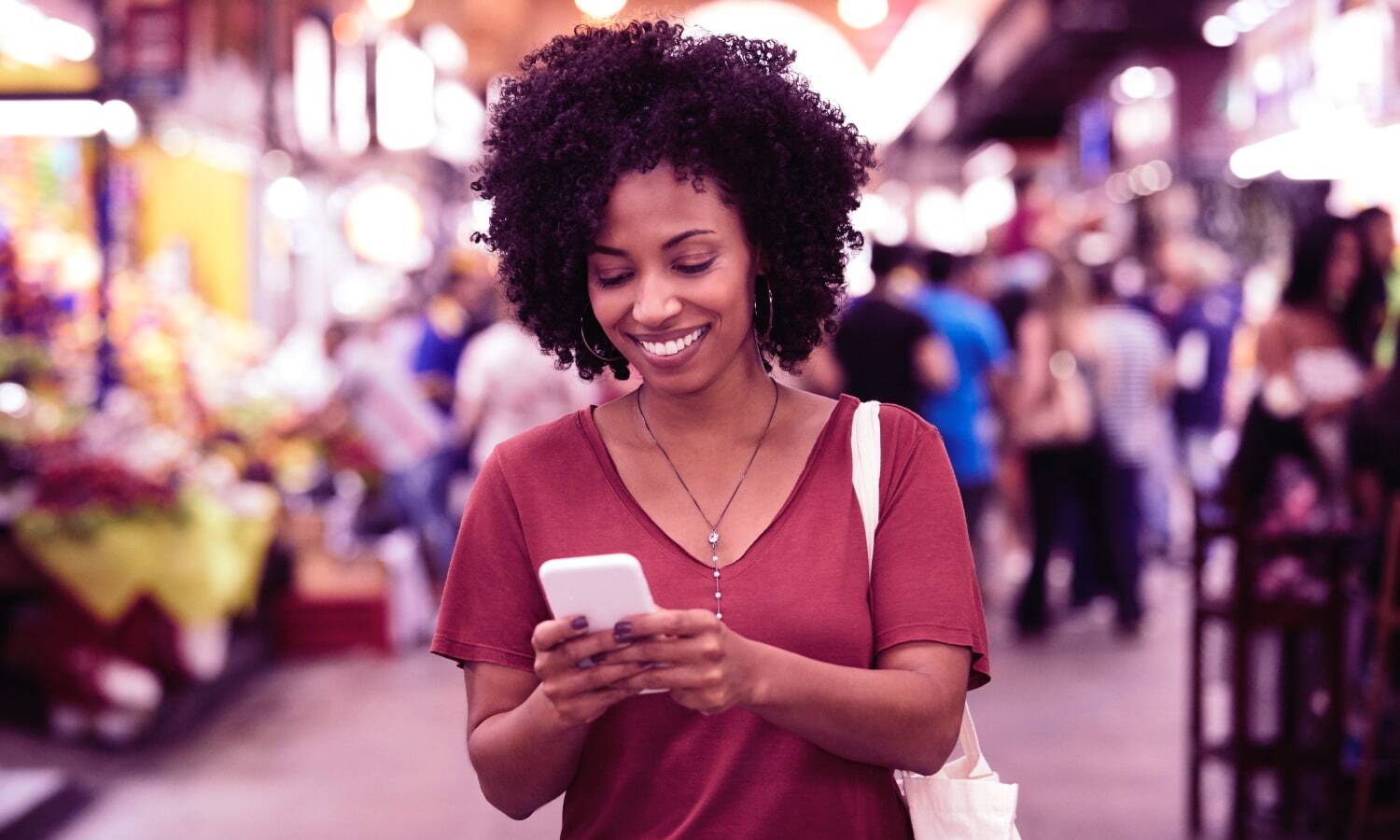 Photograph of woman using smartphone and smiling